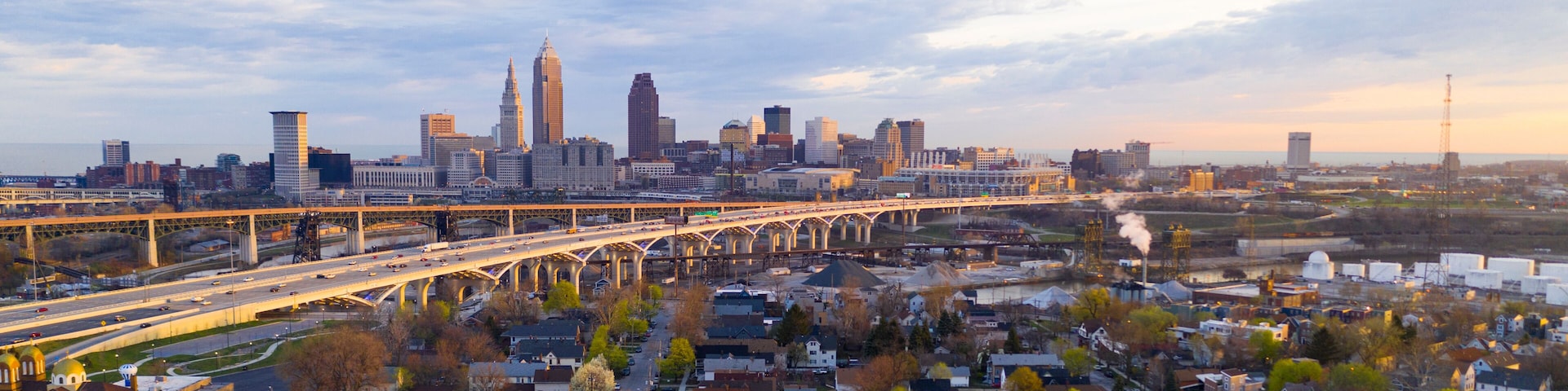 A city skyline with a prominent bridge and industrial area.