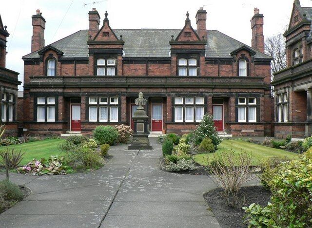 John Scott's Almshouses by Middleton Road. This is a small square of houses near the cemetery on the east side of Middleton Road. A large plaque on the gable end of the north group states "Erected and endowed by John Scott Esq. A.D. 1896" and a similar plaque on the south gable "Trustees Samuel Scott Stanley, Joseph Gale, George Mellen, Revd Canon Thompson, Robert E Emsley. John E Leak Architect". Leeds City Council's "Listed Building Gazeteer", shows that they are Grade 2 listed buildings. The bust in the centre is of John Scott and is also Grade 2 listed.
