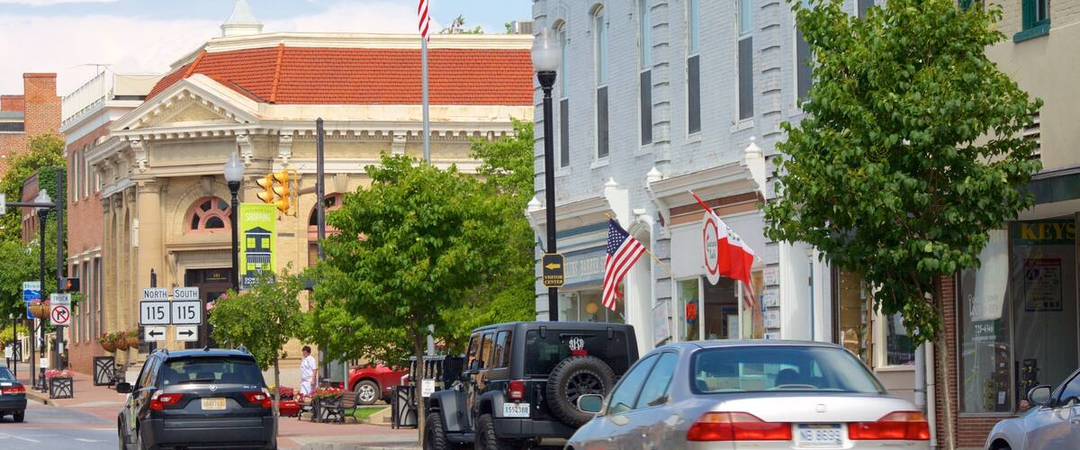 A street with cars, a Jeep, and a building with a sign that says "Visitor Center".