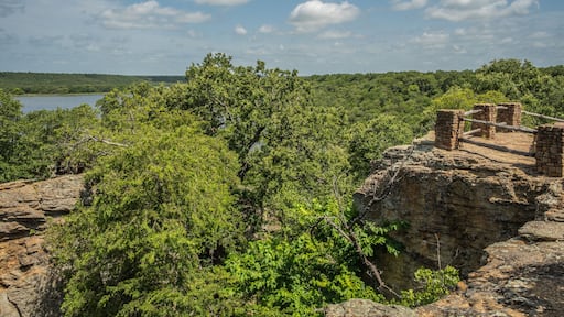 Fenced Off Viewpoint Overlooking Blue Lake Surrounded by Forest of Green Trees With Rocky Landscape in Lake Mineral Wells State Park in Mineral Wells, Texas