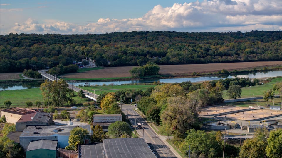 A river, a bridge, a highway, and a forested hill.