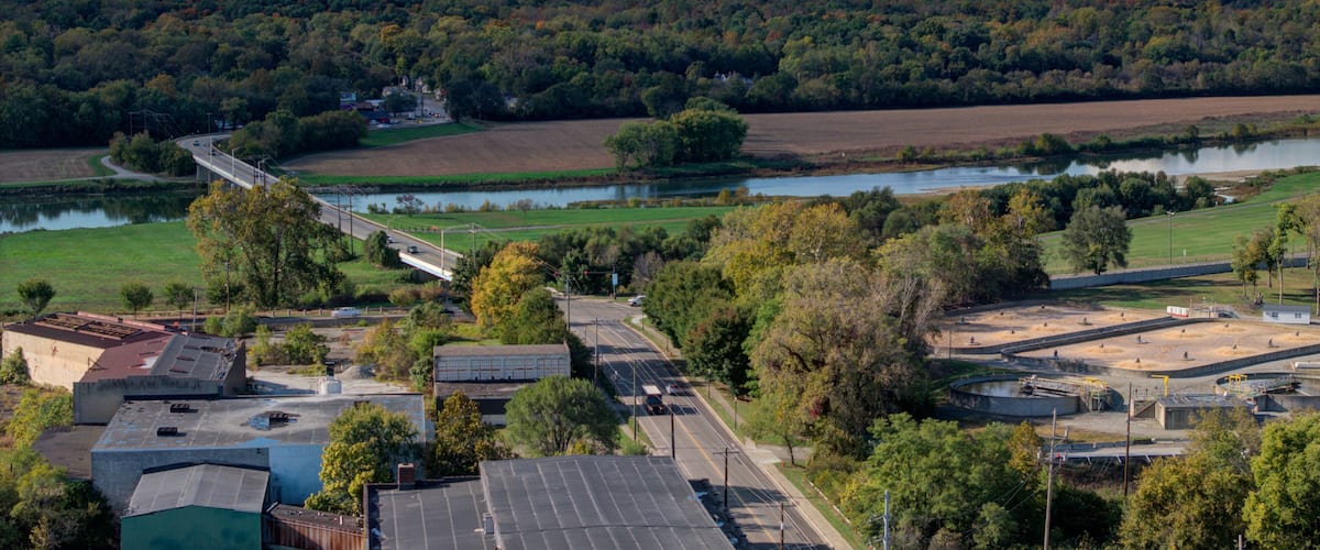 A river, a bridge, a highway, and a forested hill.