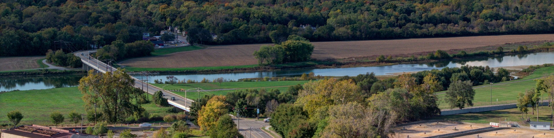A river, a bridge, a highway, and a forested hill.