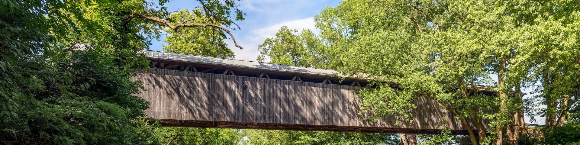 Displaying a beautiful reflection in the East Fork of the Little Miami River, historic McCafferty Road Covered Bridge was built in 1877 in rural Brown County, Ohio.