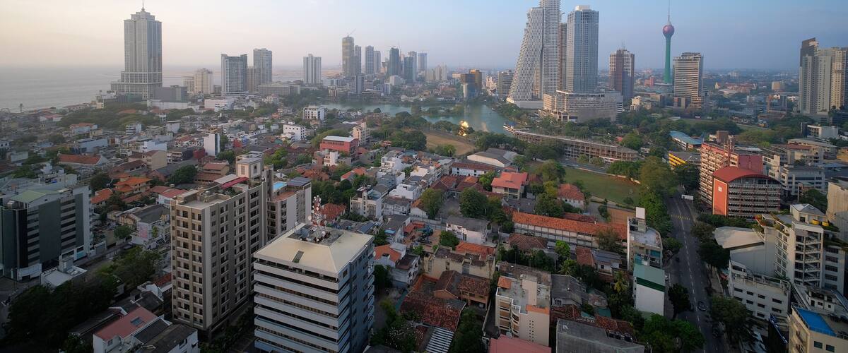 Colombo cityscape with view of Beira Lake surrounded by ny large businesses, condos and Lotus Tower