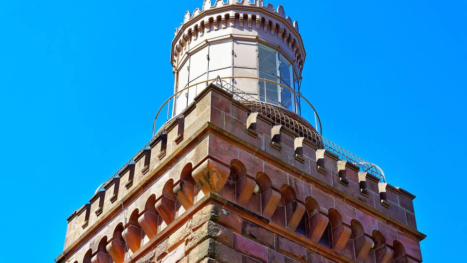 A historic tower with a rounded top and arched windows.