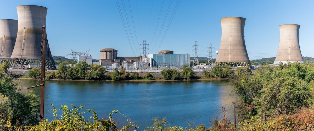 Cooling towers, a river, and industrial buildings.
