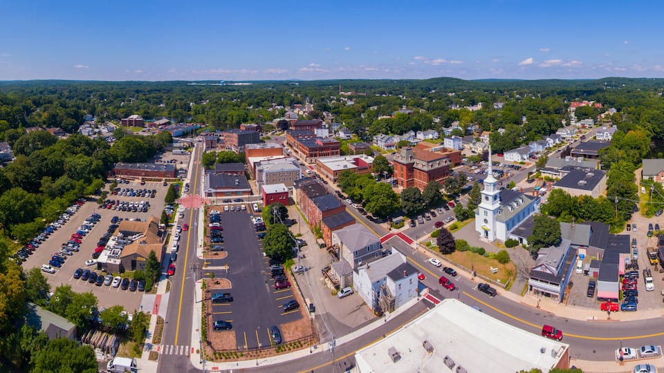 An aerial view of a town with a central square, a church, and surrounding residential areas.