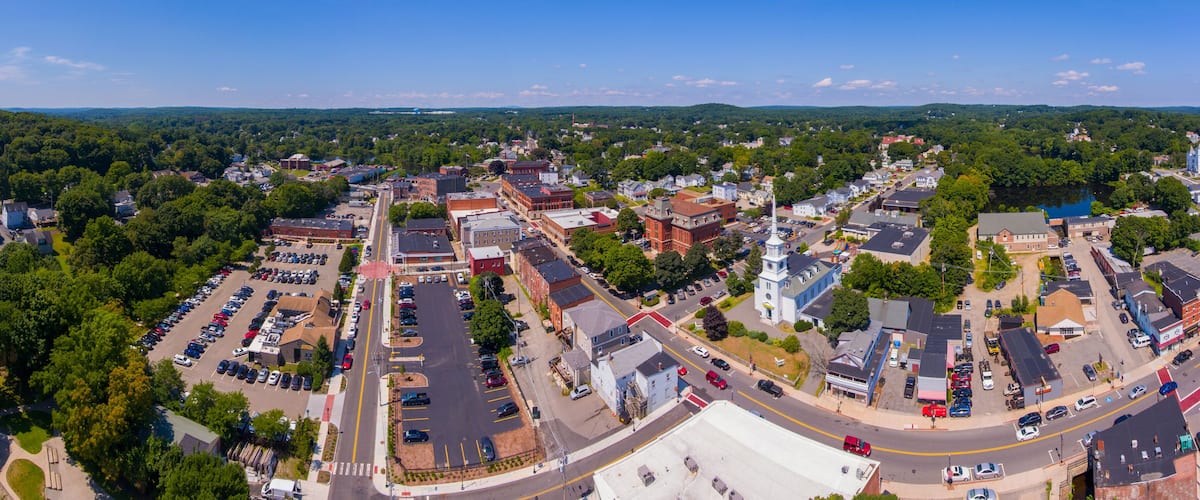 An aerial view of a town with a central square, a church, and surrounding residential areas.