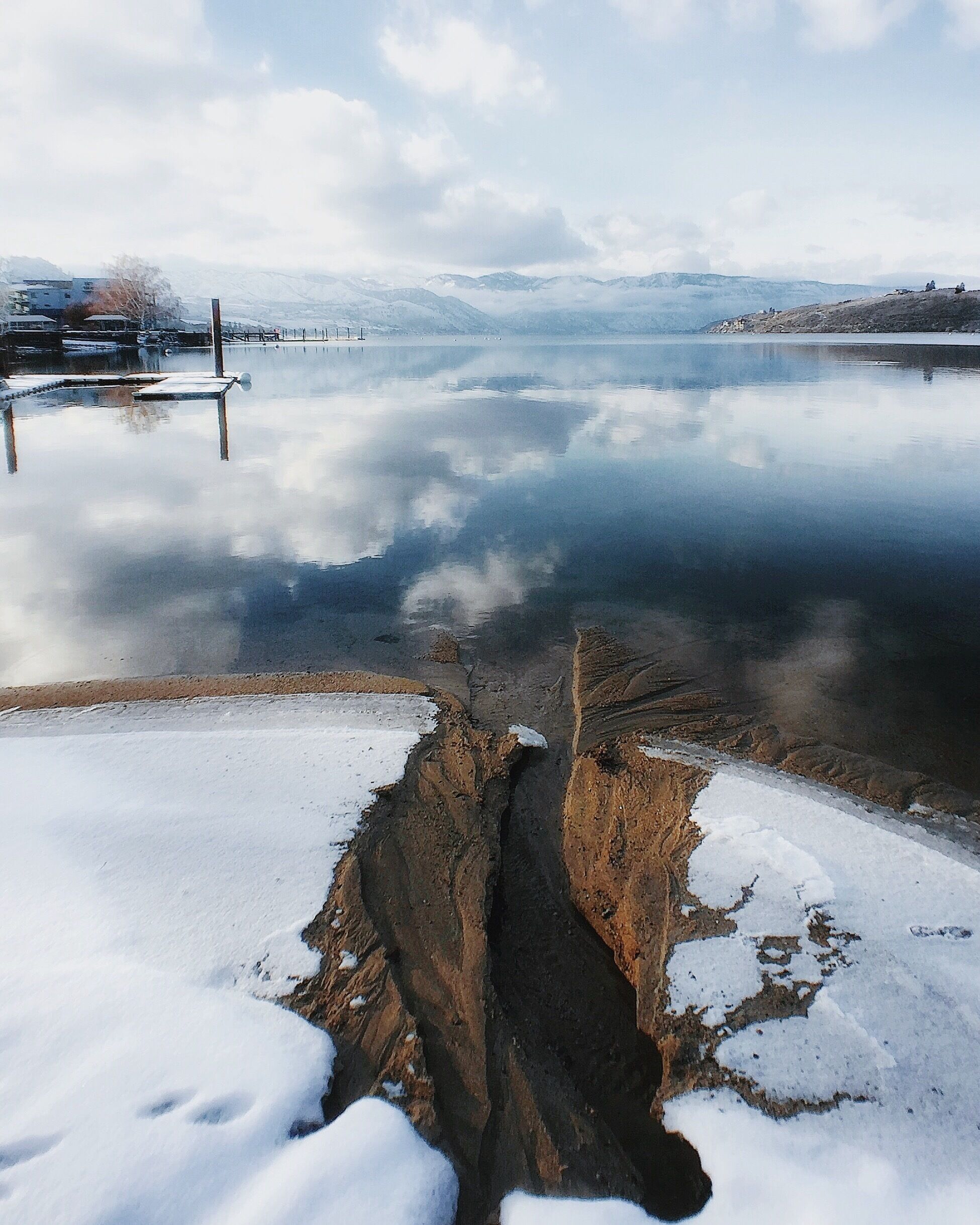 A frozen lake with a narrow, rocky gap in the center.
