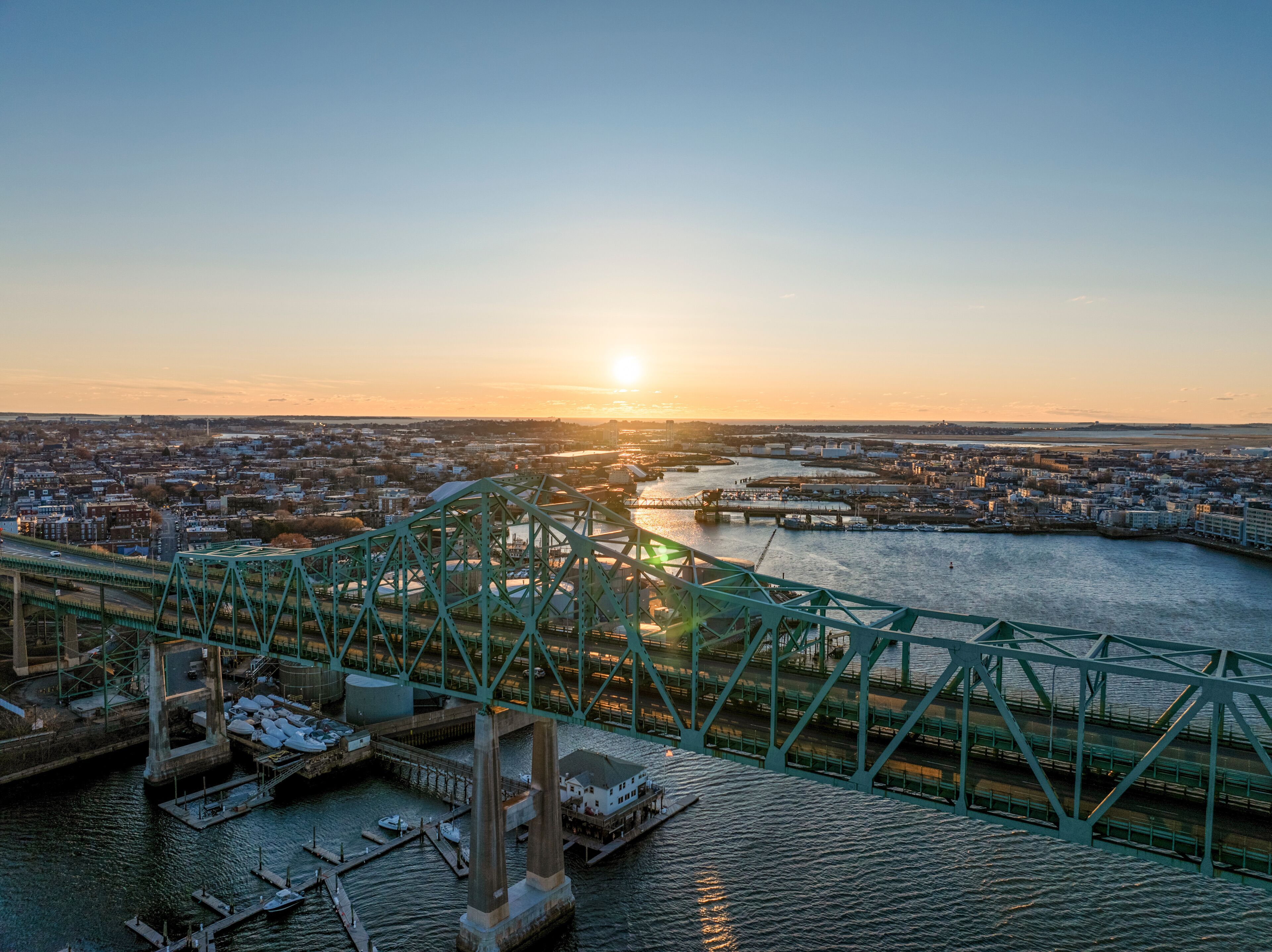 Aerial view of cityscape at sunset with bridge over river, Chelsea, Massachusetts, United States.
