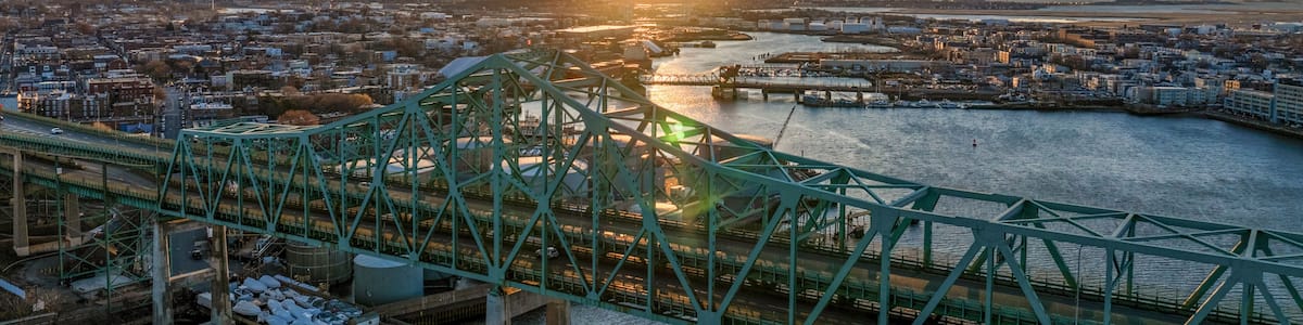 Aerial view of cityscape at sunset with bridge over river, Chelsea, Massachusetts, United States.