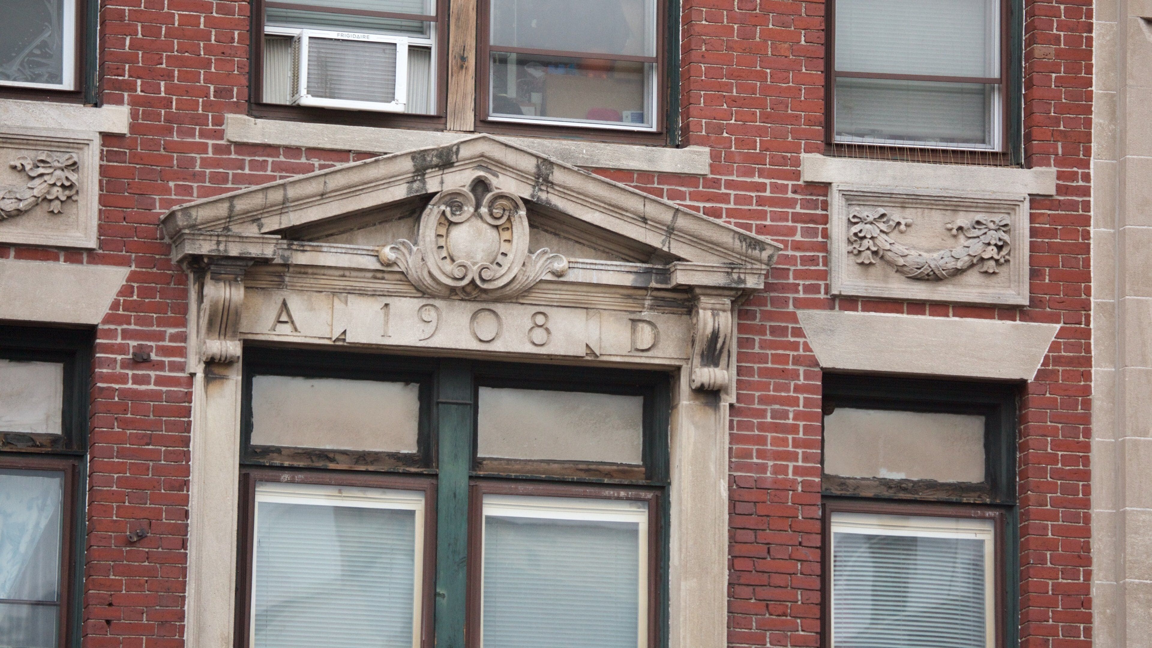 A building facade with a decorative archway above the address "A.1908 D".