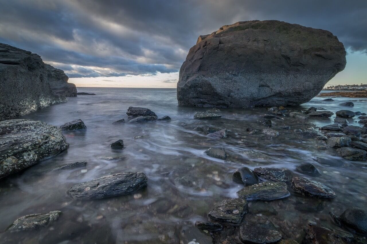 Wide angle long exposure shot at Anchor Beach in Milford Connecticut. Small town beach with the feeling of rocky Maine coastline.