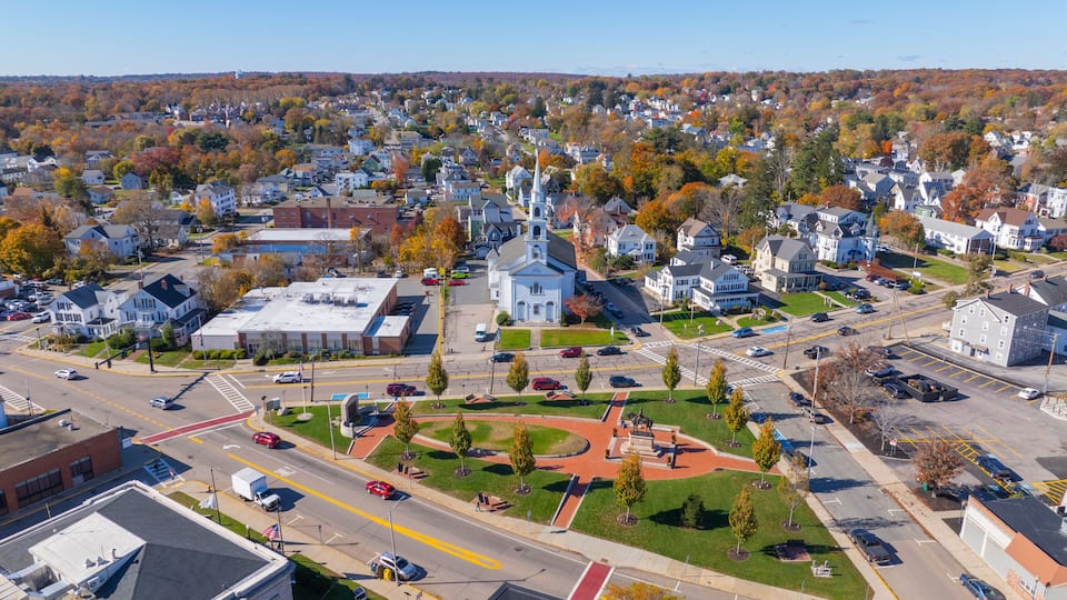 A town with a prominent church, a central square with a monument, and a mix of residential and commercial buildings.