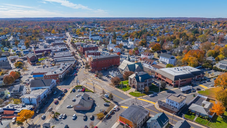 A town with a central roundabout, surrounded by residential houses and commercial buildings.