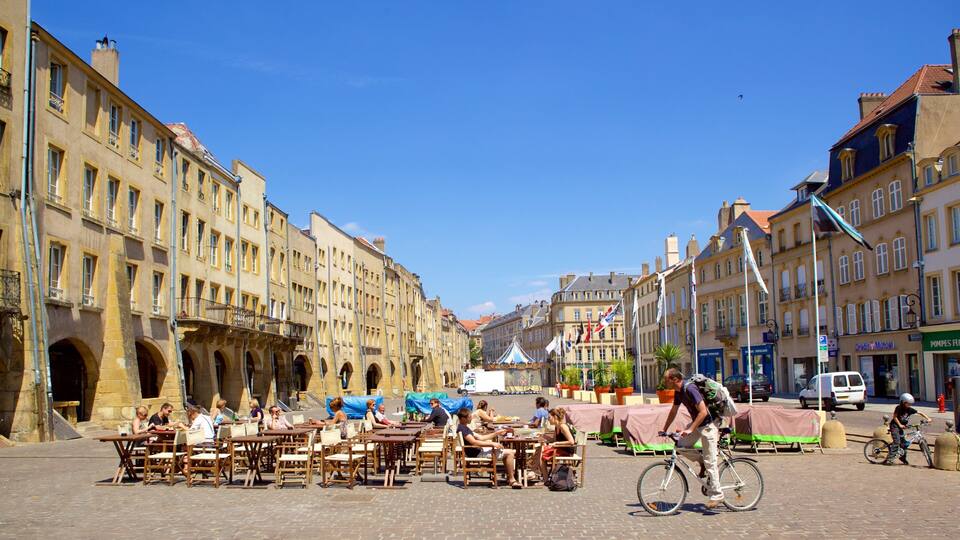 A cobblestone street with outdoor seating and historic buildings.
