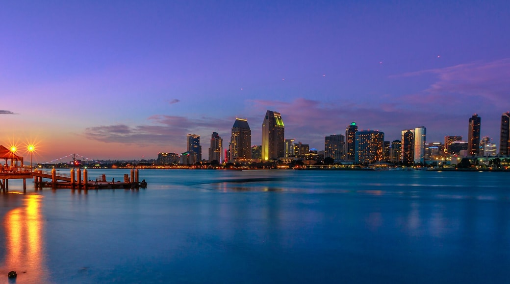 Panorama of Coronado old pier reflecting on in San Diego Bay from Coronado Island, California, USA. San Diego cityscape skyline with Downtown and Waterfront Marina District at twilight on background.