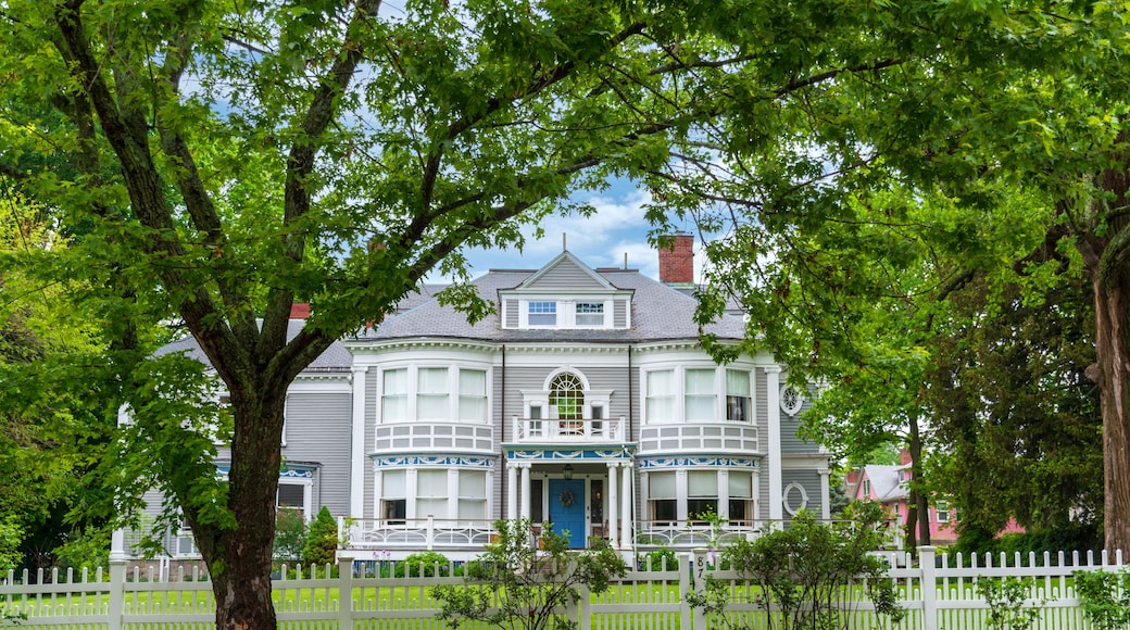 Elegant Victorian Home Framed by Lush Greenery and White Fence in Newton, Massachusetts, USA