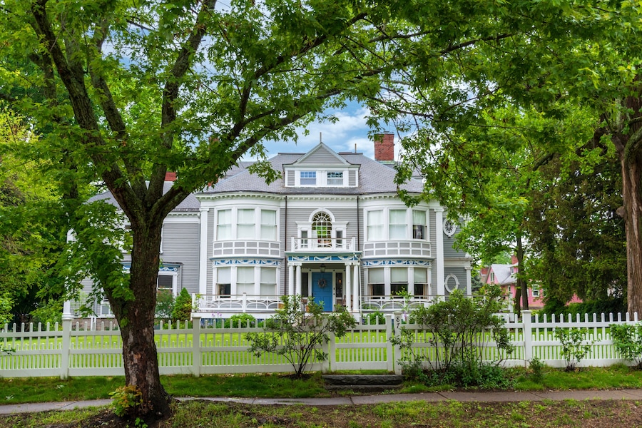 Elegant Victorian Home Framed by Lush Greenery and White Fence in Newton, Massachusetts, USA
