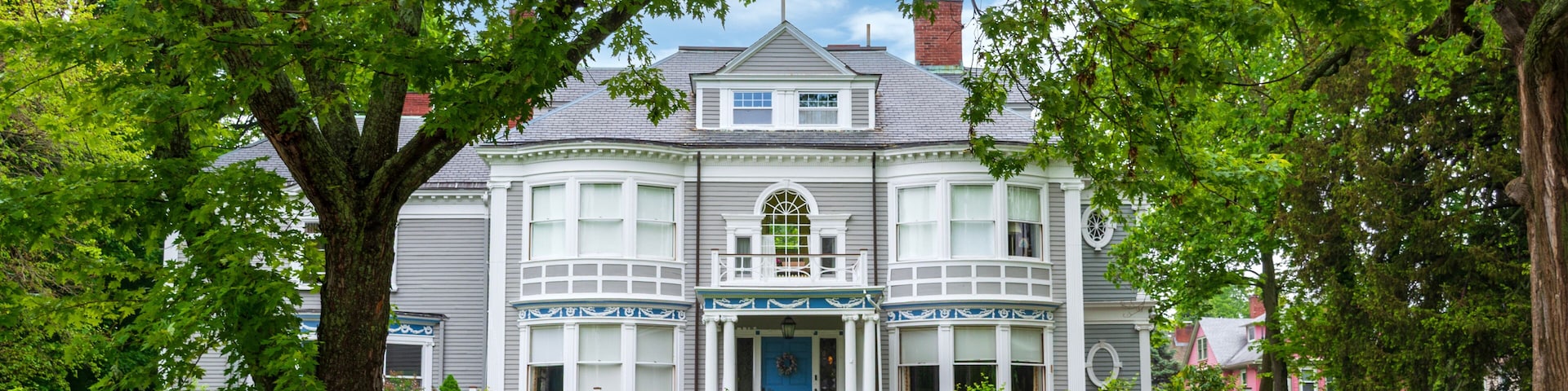 Elegant Victorian Home Framed by Lush Greenery and White Fence in Newton, Massachusetts, USA