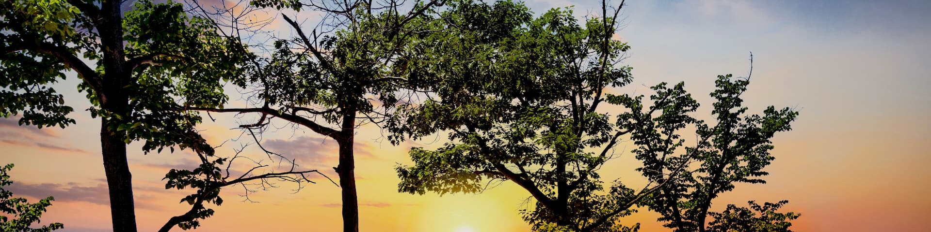 The silhouette of Indiana Dunes State Park landscape overlooking Lake Michigan at sunset near Porter, Indiana, USA.