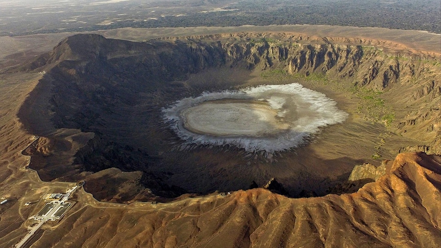 (Al Wahbah crater)
The mouth of the Al-Wa'bah locally called the mud quarry) is located in the desert of the Kingdom of Saudi Arabia, 254 km from Taif and on the western edge of the basalt plateau hills that contain many volcanic cones. This crater is the largest of its kind in the Middle East, with a diameter of 2 km and a depth of 250 meters and has a flat base covered by a thick crust of white sodium phosphate crystal.
It was believed that the crater resulted from the fall of a meteorite, because its outer appearance resembles meteor craters in its circular shape and the height of its sides, but today geologists agree that the crater was formed by volcanic activity that led to an underground explosion that generates steam by the contact of molten rock with groundwater.