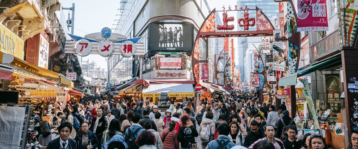 A crowded street with various shops and signs in Japanese.