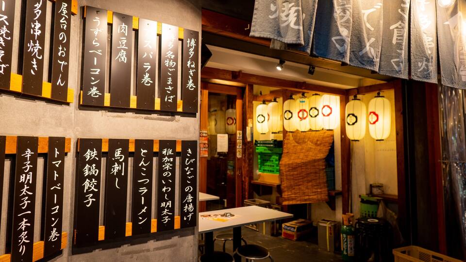 A traditional Japanese restaurant interior with wooden signage and lanterns.