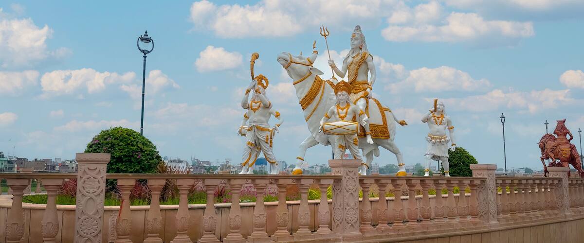A series of statues on a bridge with ornate railings and a clear sky.