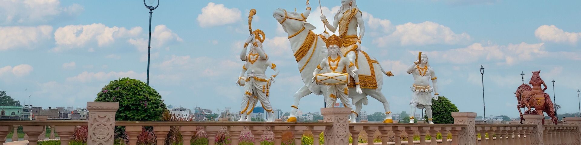A series of statues on a bridge with ornate railings and a clear sky.