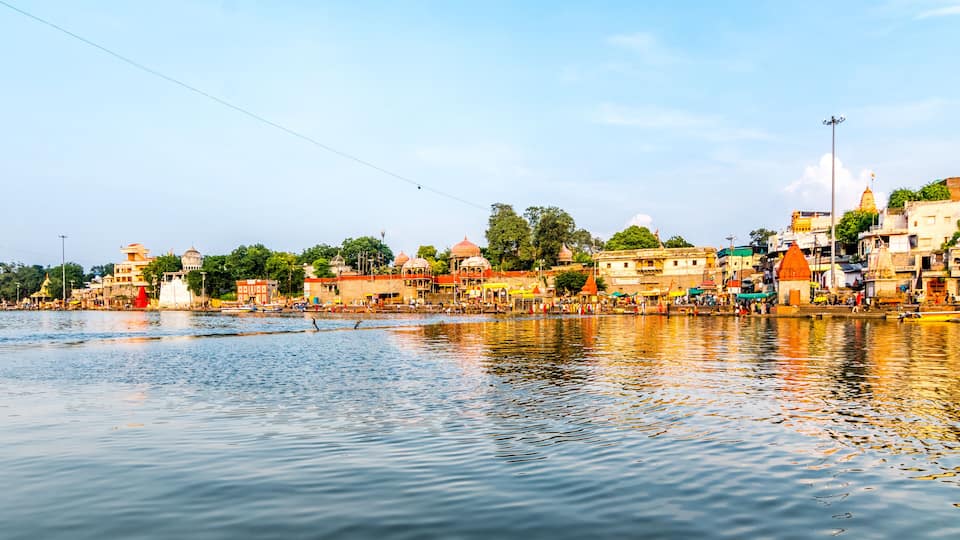 A riverside town with historic buildings, a bridge, and a temple.