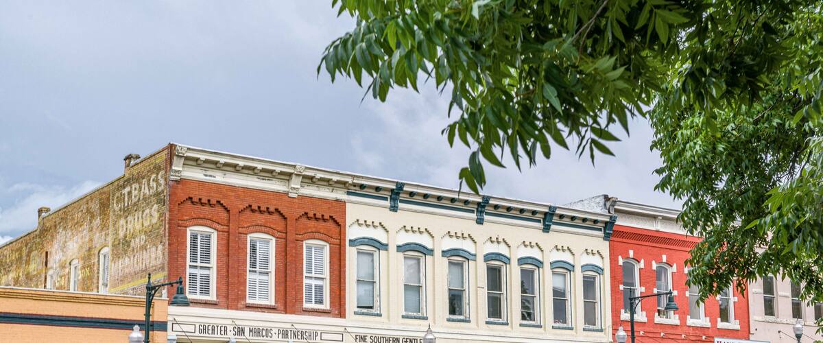 A row of historic buildings with storefronts, including a bank and a restaurant.