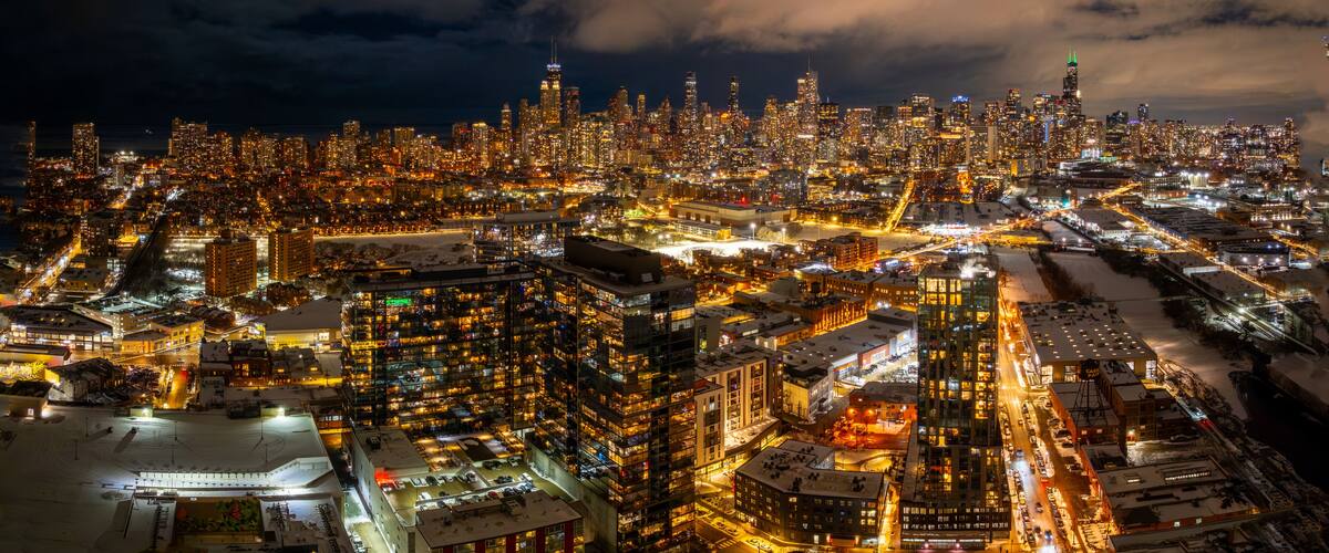 A nighttime cityscape with dense urban architecture and illuminated streets.