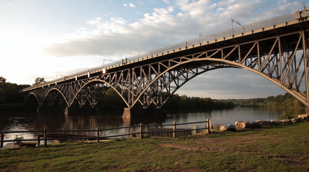 View of steel arch bridge Strawberry Mansion Bridge crossing the Schuylkill River in Fairmount Park under sunset in Philadelphia, Pennsylvania, USA