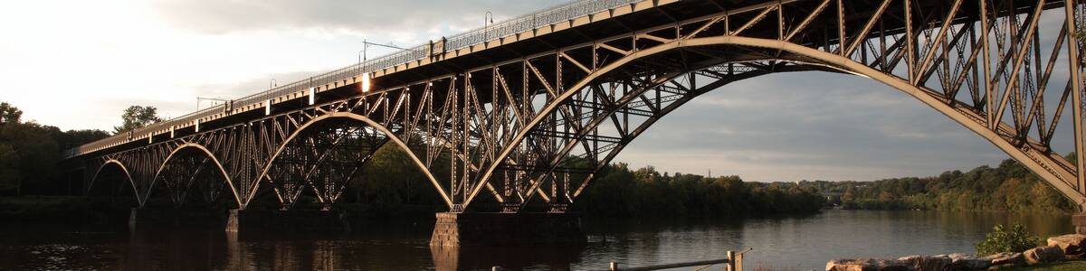 View of steel arch bridge Strawberry Mansion Bridge crossing the Schuylkill River in Fairmount Park under sunset in Philadelphia, Pennsylvania, USA