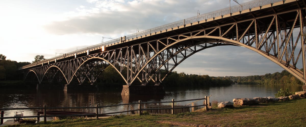 View of steel arch bridge Strawberry Mansion Bridge crossing the Schuylkill River in Fairmount Park under sunset in Philadelphia, Pennsylvania, USA