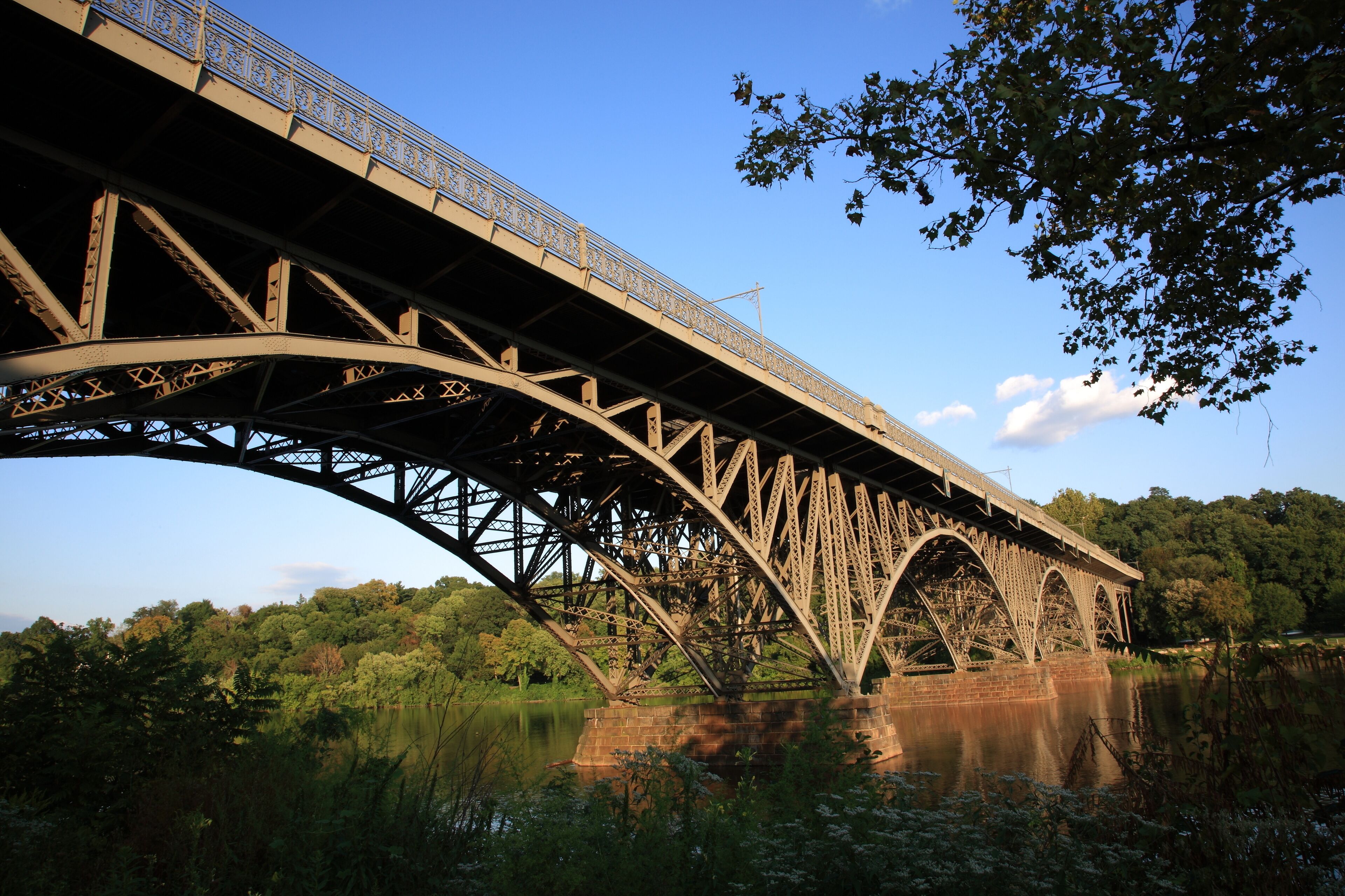View of steel arch bridge Strawberry Mansion Bridge crossing the Schuylkill River in Fairmount Park under sunset  in Philadelphia, Pennsylvania, USA