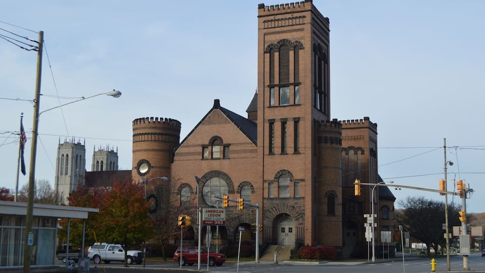 A historic church with a clock tower and a large circular window.