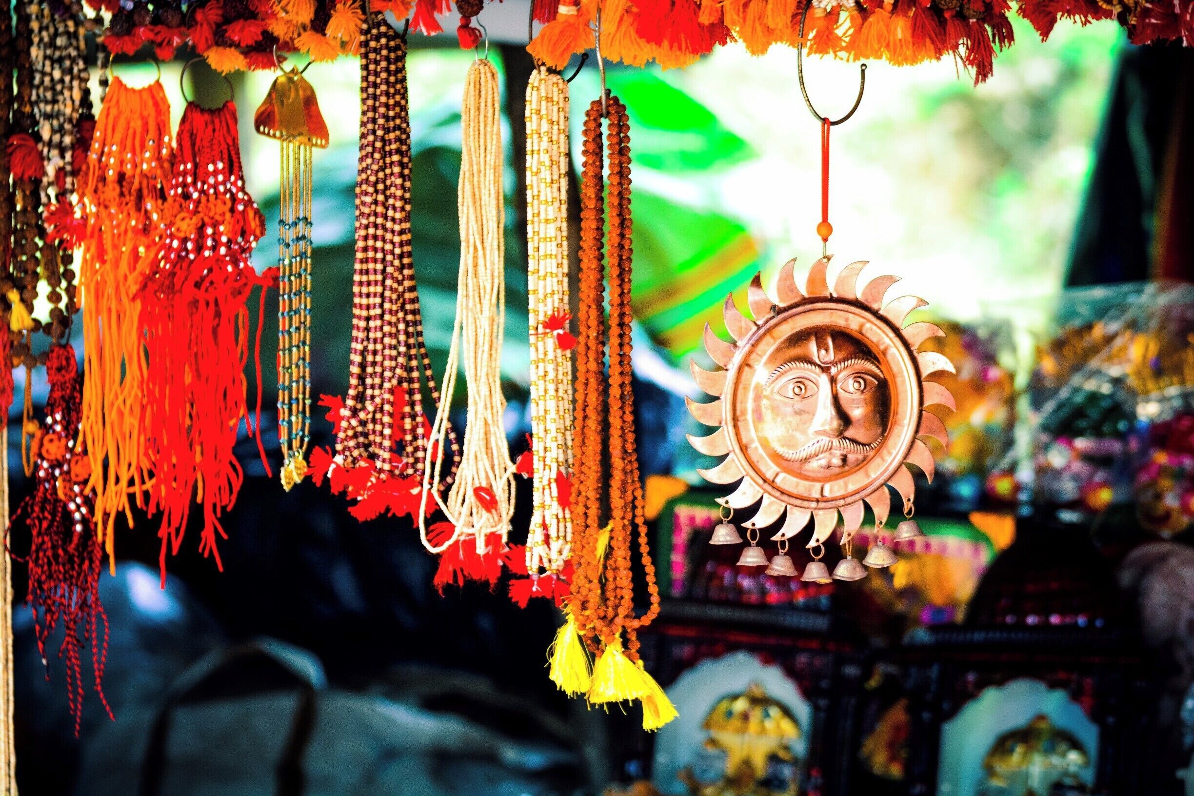 A variety of colorful prayer beads and a decorative sun-shaped ornament.