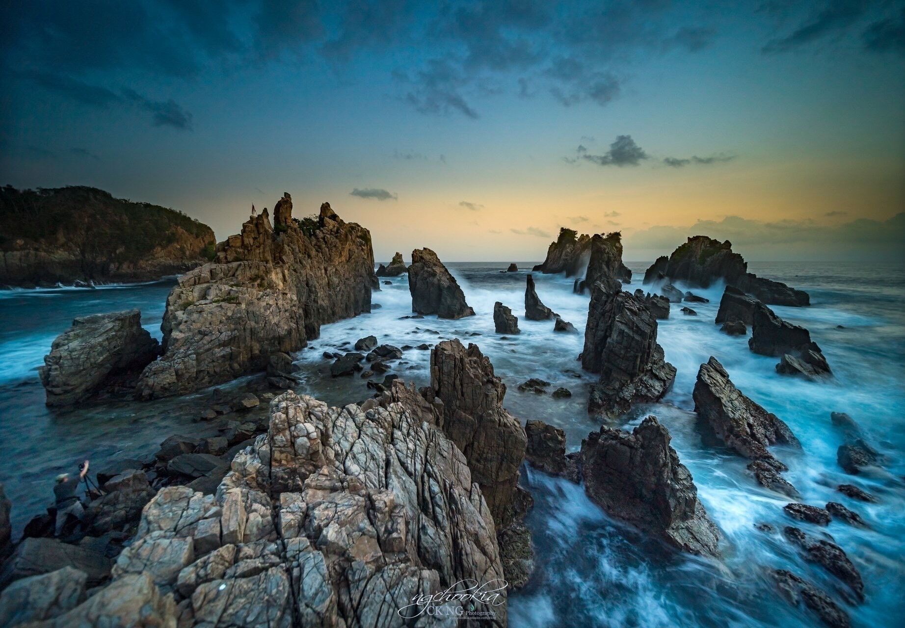 A coastal landscape with prominent rock formations and a body of water.