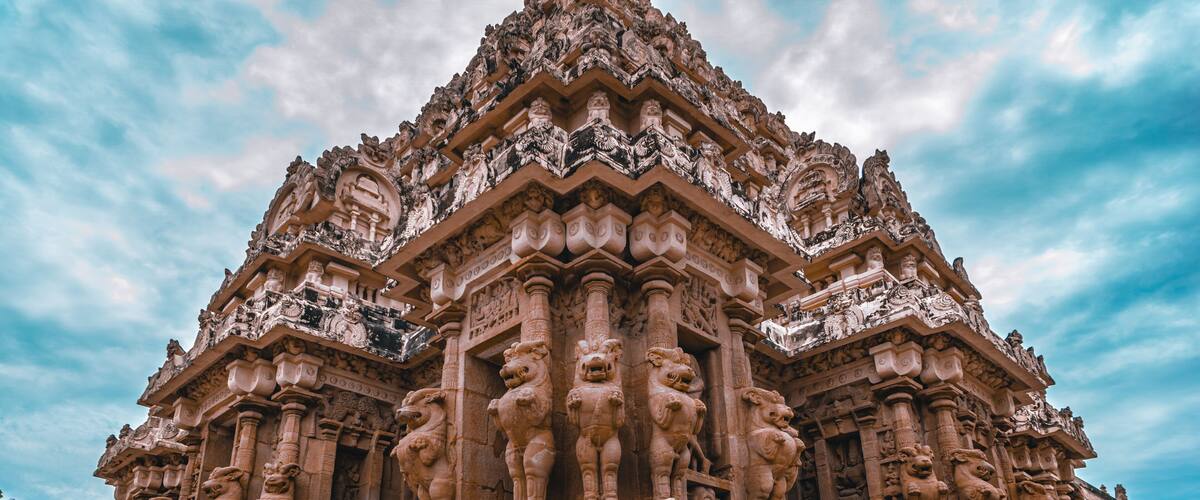 A detailed stone temple with intricate carvings and lion statues.