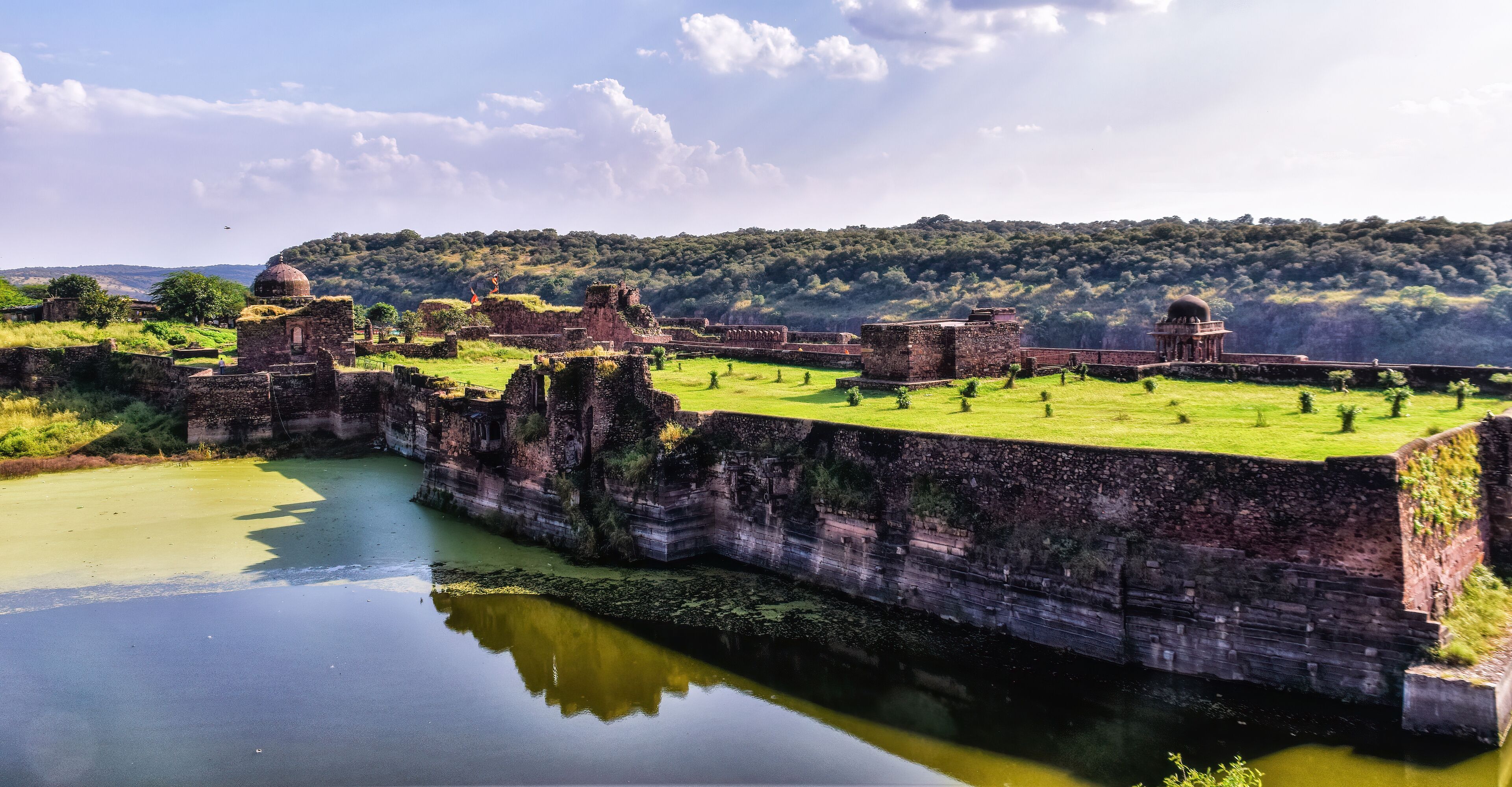 Ancient ruins with domed structures and a river.