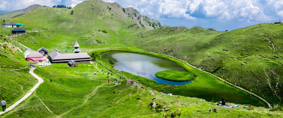 A green valley with a lake, a church, and a path.
