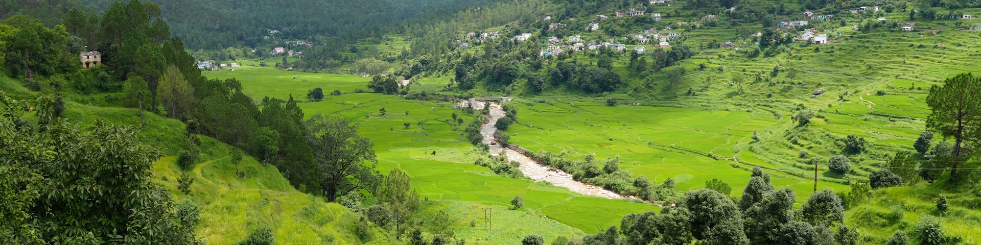 A valley with terraced fields, a river, and a small settlement on the hillside.