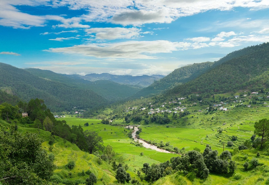 A valley with terraced fields, a river, and a small settlement on the hillside.
