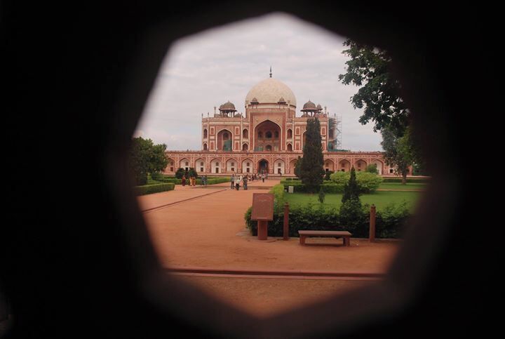 Le Taj Mahal vu de loin, avec une vue dégagée sur son imposant dôme central et ses minarets symétriques.