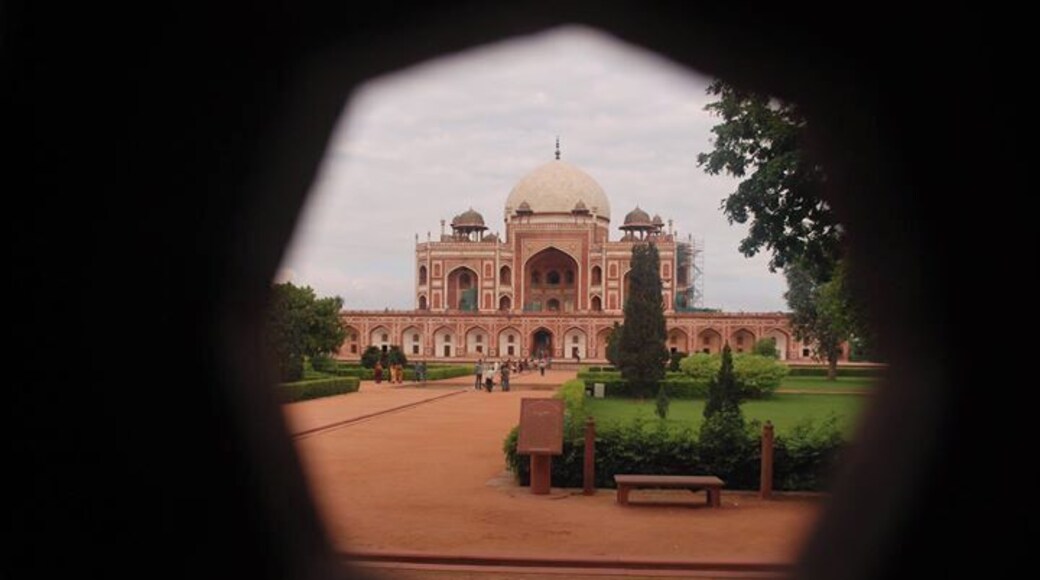 Le Taj Mahal vu de loin, avec une vue dégagée sur son imposant dôme central et ses minarets symétriques.