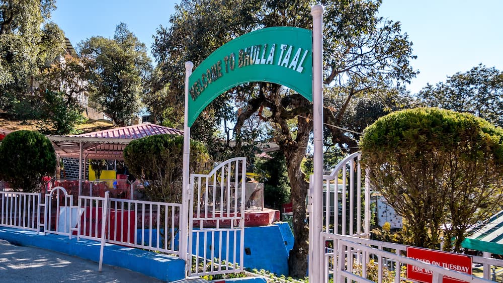 A sign welcoming visitors to Brula Taala, surrounded by trees and a fenced area.