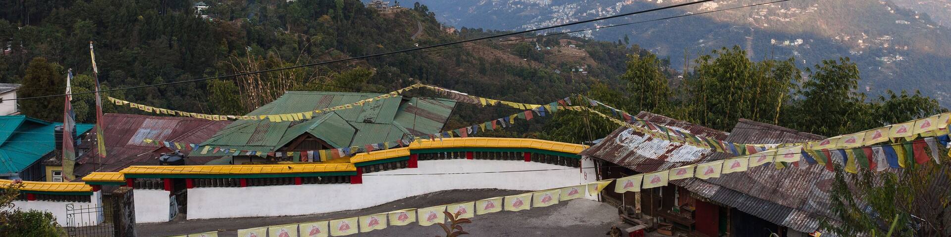 A mountainous landscape with a village featuring traditional buildings and prayer flags.